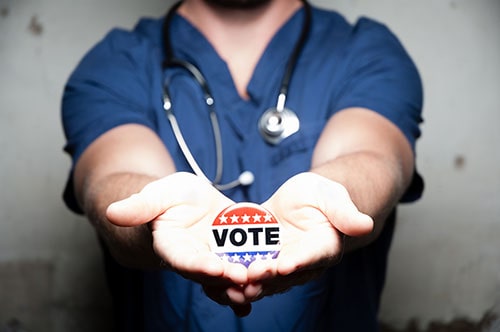 Hospital worker holding vote button