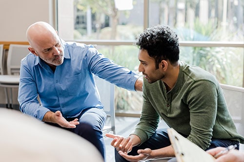 Two men sitting together and talking